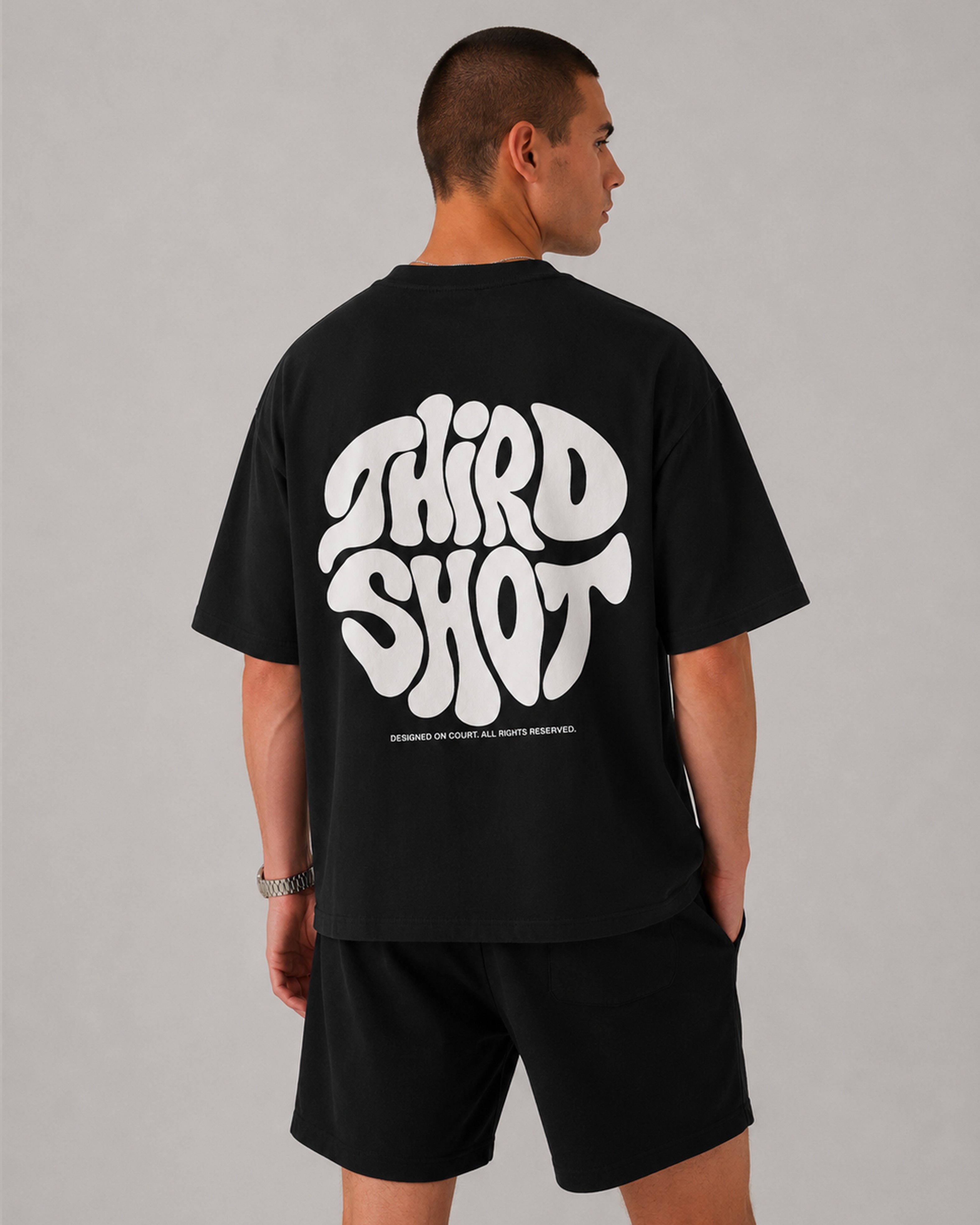 Retro Tee in black — flat-lay on the padel court, Third Shot heavyweight cotton graphic tee