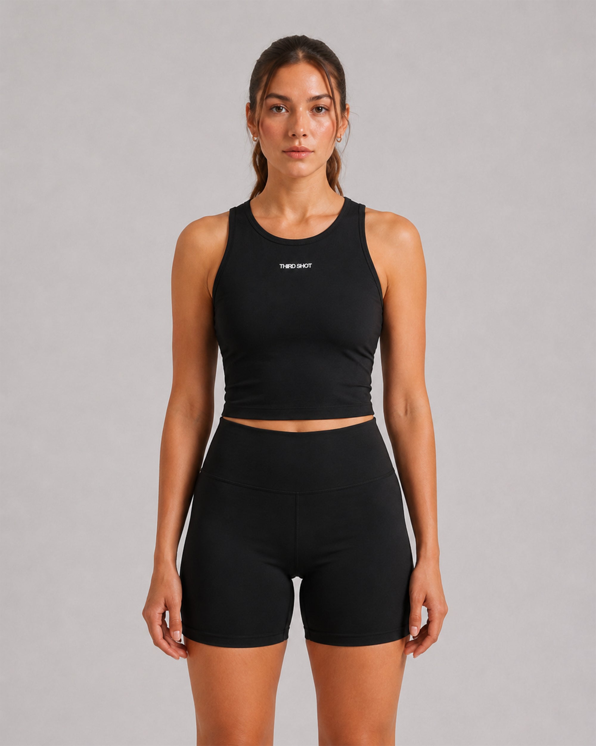 Model wearing the Women's Sports Crop Tank in black with matching bike shorts, front view